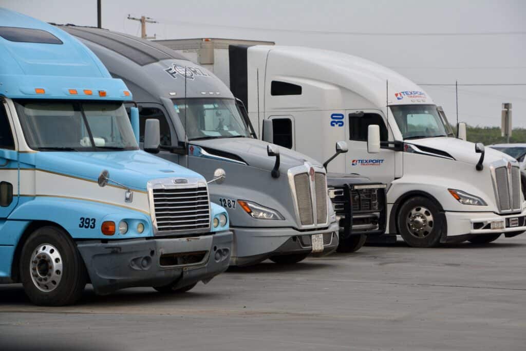 Fila de tractocamiones estacionados en una terminal de carga