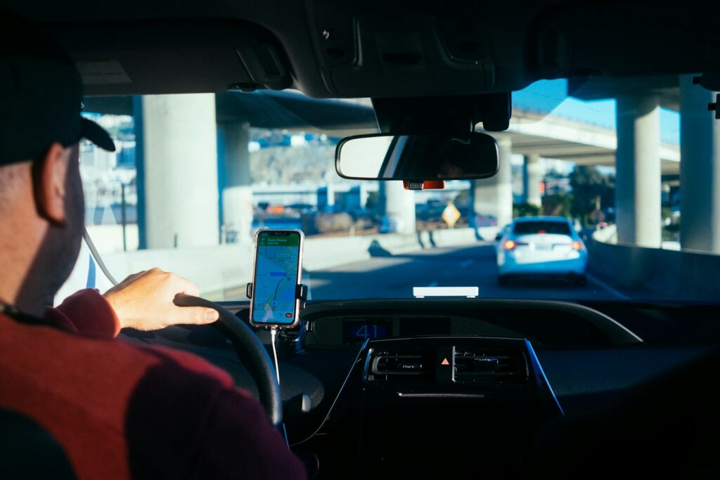 Conductor siguiendo una aplicación de navegación en un teléfono montado en el carro