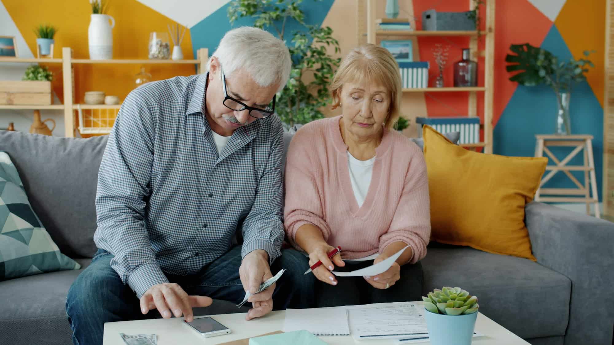Older couple reviewing medical bills and settlement paperwork at home